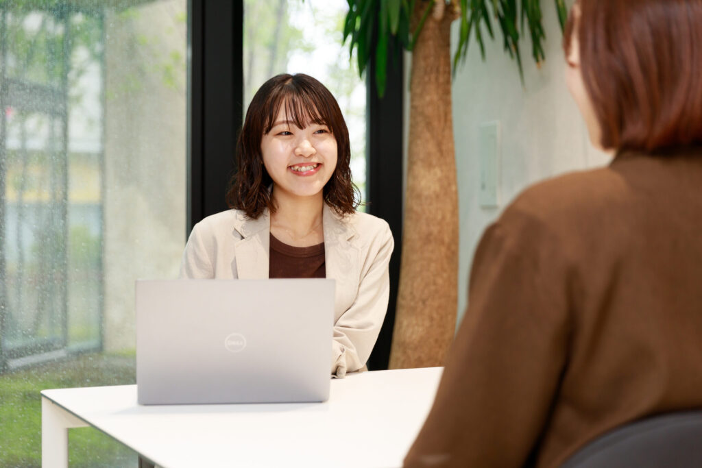 パソコンを挟んで会話する社員
